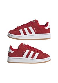 Sneaker in suede rosso con design a tre strisce bianche, suola piatta in gomma bianca e collare della caviglia imbottito. Logo "CAMPUS" sul lato.