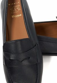 Black leather loafers with a wide fit design, featuring a smooth texture, decorative stitching, and a subtle v-shaped cutout accent.