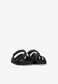 Black sandals featuring textured straps, an open design, and a flat sole. The material appears smooth with cut-out details.
