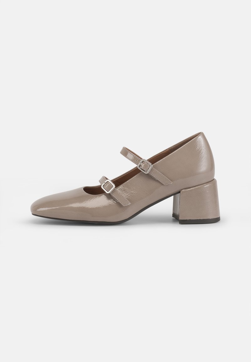 Chaussure Mary Jane en cuir verni beige avec un bout pointu, deux sangles ajustables et un talon épais et carré. Texture lisse et matériel minimal.