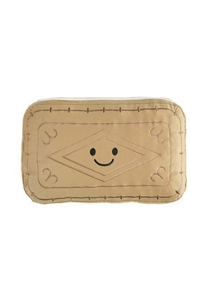 Pehme suorakaiteen muotoinen beige tyyny, jossa ommellut koristekuviot ja musta hymyilevä kasvot keskellä yksinkertaisella valkoisella taustalla.