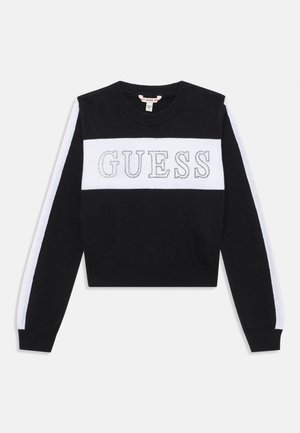 Black sweater with a white stripe and the word "GUESS" in silver embroidery across the chest. Crew neck, long sleeves, and ribbed hem.
