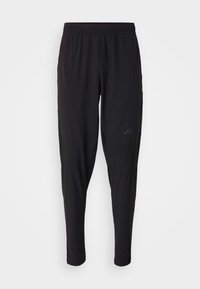 Zwarte sportbroek met een elastische tailleband, taps toelopend ontwerp, zijzakken en subtiele logodetails. Gemaakt van flexibele, ademende stof.