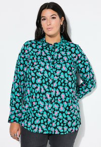 Button-up Hemd mit schwarzem Grund und einem auffälligen türkis- und pinkfarbenen abstrakten Muster. Lange Ärmel und ein klassischer Kragen runden das Design ab.