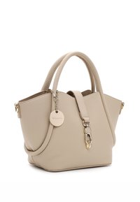 Beige leren handtas met twee korte handvatten. Heeft een gouden sleutelhanger en een sluiting, gestructureerd ontwerp met een ronde bodem en een open bovenkant.