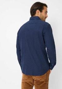 Camicia a maniche lunghe blu navy in tessuto testurizzato con colletto e polsini a bottoni, caratterizzata da un orlo dritto e una vestibilità su misura.