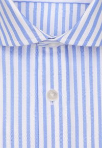 Lichtblauw en wit gestreept shirt met een puntige kraag, verticale visgraat patroon en een doorzichtige knop bij de sluiting.