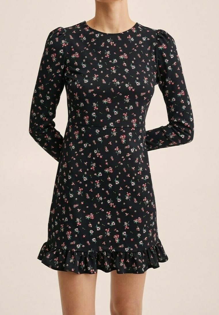 Musta mekko pitkillä hihoilla, punaisen ja vihreän kukkakuosin kanssa, istuva vartalonmyötäinen malli ja röyhelöhelma. Valmistettu sileästä kankaasta.