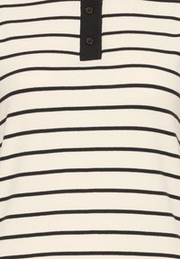 Tissu blanc avec des fines rayures horizontales noires espacées régulièrement et une patte de boutonnage noire avec deux boutons.