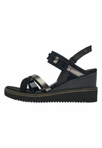 Sandale noire avec un talon compensé, ornée de multiples lanières de textures variées, comprenant des motifs lisses et crocodile, avec une sangle de cheville flexible.