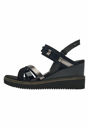 Sandale noire avec un talon compensé, ornée de multiples lanières de textures variées, comprenant des motifs lisses et crocodile, avec une sangle de cheville flexible.
