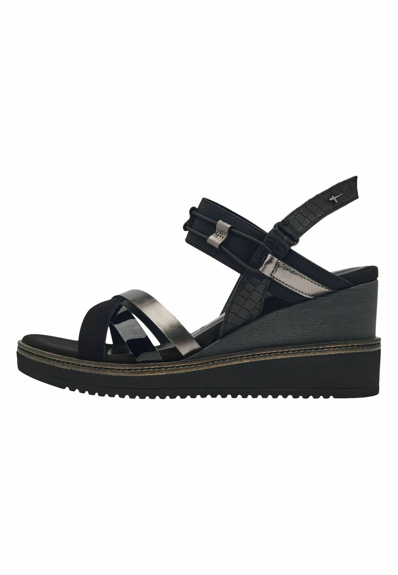 Sandale noire avec un talon compensé, ornée de multiples lanières de textures variées, comprenant des motifs lisses et crocodile, avec une sangle de cheville flexible.