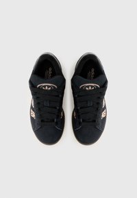 Sapatilhas de camurça preta com atacadores pretos e sola de borracha natural. Apresentam um detalhe de padrão de leopardo nas laterais e um logótipo da adidas na lingueta.