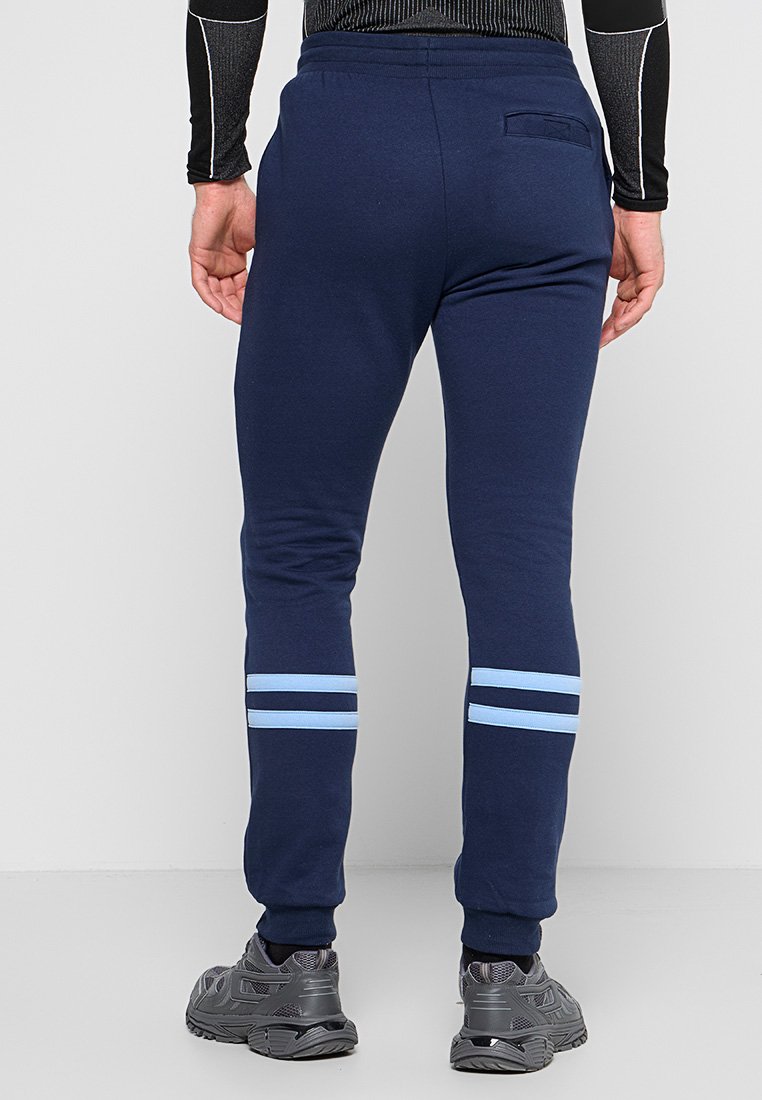 Marineblaue Jogginghosen aus Baumwollmischung, mit zwei hellblauen Streifen in der Nähe der Knöchel und einer Gesäßtasche. Weicher Stoff und taillierter Schnitt.