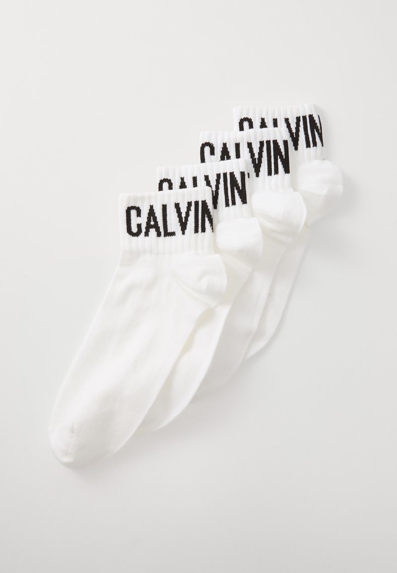 Baltos medvilnės kojinės su juodu "CALVIN" logotipu ant pūkuotų kraštų, pasižyminčios lygia tekstūra ir klasikiniu sportiniu dizainu. Rinkinys iš keturių porų.