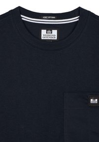 Dark navy cotton t-shirt with a crew neck, featuring a small chest pocket and a branded patch. White striped detail at the collar.