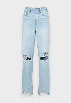 Heled sinine denimist teksapüksid kõrge vöökoha, laia jala, kulunud kangaga, millega kaasnevad kaks suurt põlvepisarat ja rebenenud ääred.