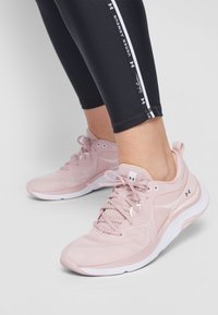 Scarpe da ginnastica rosa chiaro realizzate in materiale mesh e sintetico, con design a lacci, colletto imbottito e suola in gomma bianca.