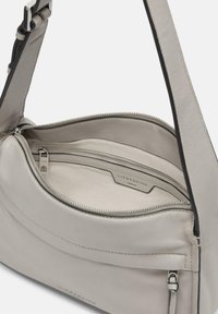 Szara skórzana torba na ramię o gładkiej fakturze, z główną kieszenią zapinaną na zamek błyskawiczny i wewnętrzną kieszenią. Logo tłoczone z boku.