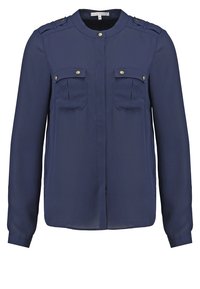 Blusa a maniche lunghe blu navy realizzata in tessuto leggero, con due tasche sul petto e dettagli in oro sui passanti delle spalle.