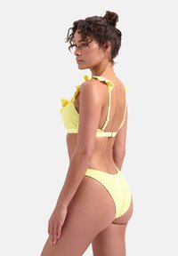 Felle gele bikini met textuurstof; bralette met ruches en verstelbare bandjes; hoge uitsnede onderkant met een gladde afwerking.