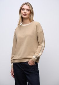 Sudadera de cuello redondo beige con tejido texturizado, rayas en off-white contrastantes a lo largo de las mangas y puños y dobladillo de canalé.