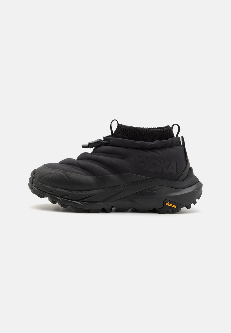 Musta ulkokenkä, jossa on pehmustettu yläosa, joustava kaula ja kestävä pohja, jossa on Vibram-logo. Texturoitu materiaali parantaa pitoa.