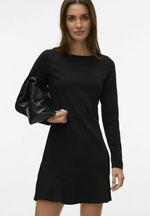 Robe noire à manches longues avec un col rond et une bordure évasée, accompagnée d'un sac à main noir en texture douce. Matière lisse et ajustée.