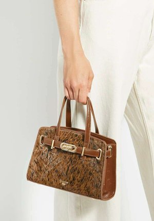 Brown handbag featuring a textured fur-like front, smooth leather sides, gold hardware, dual handles, and a zip closure.