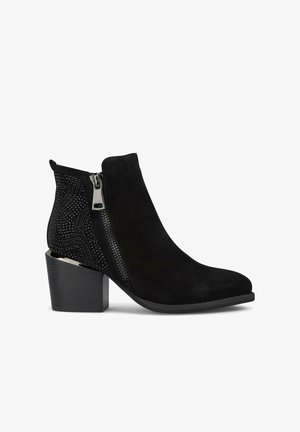 Botines negros que presentan un upper de ante con un panel de malla y tachuelas decorativas, un cierre lateral y un tacón cuadrado.