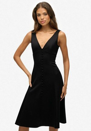 Schwarzes ärmelloses Kleid mit V-Ausschnitt, tailliertem Oberteil und ausgestellt Rock. Verfügt über eine Knopfleiste in der Mitte. Glatte Textur.