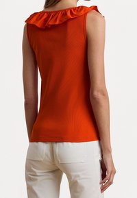 Ärmlös orange topp med en volangtopp i satin. Den är tillverkad av ribbad tyg, har en figurnära design och en rak nederkant.