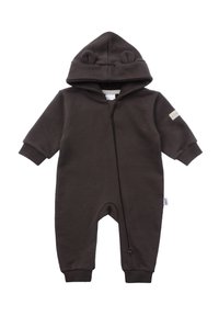 Brown fleece onesie with bear ears on hoodie, front zipper, ribbed cuffs, and a small label on the left sleeve. Soft, warm fabric.