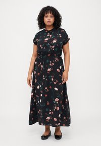 Black maxi dress with floral print in pink and green, short sleeves, buttoned collar, and an elastic waist for a relaxed fit.