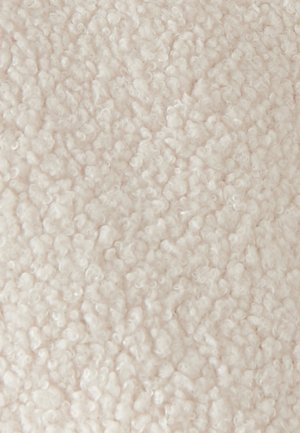 Tissu texturé de couleur beige clair avec une surface duveteuse, comportant de petites fibres enroulées. Pas de motifs ou de détails supplémentaires visibles.