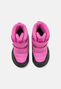Bottes imperméables roses avec semelles extérieures en caoutchouc noir, dotées de deux bandes Velcro et de tiges en tissu texturé pour l'isolation et le confort.