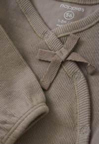 Taupe geribbelde baby romper met lange mouwen, drukknoopjes en een gebreide strik op de borst, maat 56 voor 1-2 maanden oud.