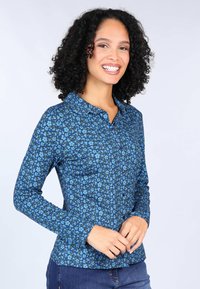 Blue floral-patterned button-up shirt with long sleeves, featuring a pointed collar and a slim fit design. Constructed from soft fabric.
