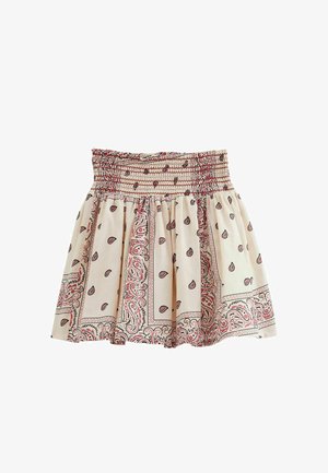 Jupe couleur crème avec une taille froncée, ornée d'un motif paisley en rouge et noir, et une coupe évasée avec un tissu texturé.