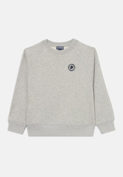 Hellgraues Langarm-Crewneck-Sweatshirt mit gerippten Bündchen und Saum, das ein kleines rundes Marineblaues Logo auf der linken Brust zeigt.