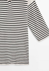 Tissu blanc avec de fines rayures horizontales noires uniformément espacées, montrant une manche longue et une partie du torse.