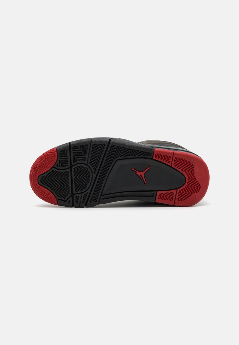 Suela de zapatilla negra y roja con un diseño de banda de rodadura con patrón, que presenta un logo prominente y una superficie texturizada para tracción y durabilidad.