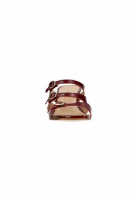 Red patent leather sandals with three adjustable straps and gold hardware accents. Open-toe design and a flat, natural-colored sole.
