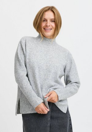 Vaaleanharmaa, korkeakauluksinen neulepaita, jossa on pitkät hihat, sivureiät ja tekstuuripinta. Materiaali vaikuttaa pehmeältä ja lämpimältä.
