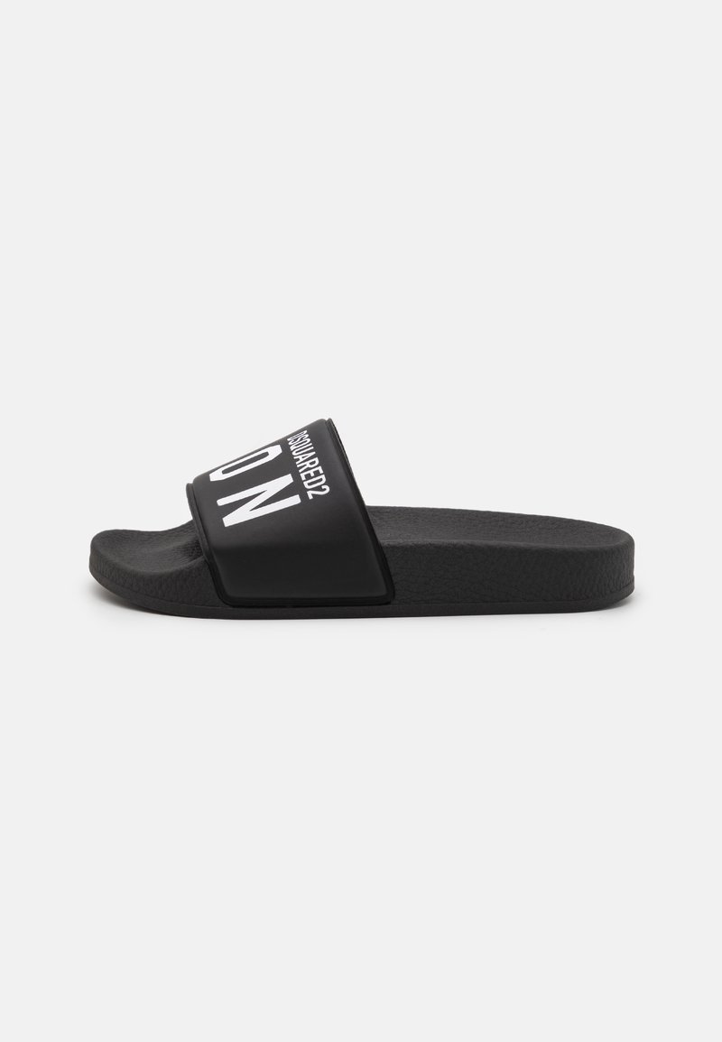 Black slide sandal with a textured sole and wide strap featuring white lettering. Minimalist design with no additional embellishments.