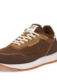 Baskets marron et beige avec un dessus en feutre, des accents en daim, des détails en simili cuir et des lacets blancs, le tout reposant sur une semelle en caoutchouc texturé.