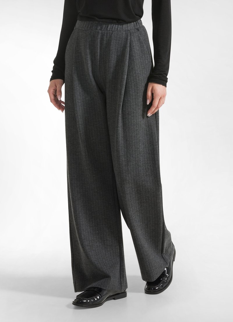Grijze, wijde broek met een subtiele streep patroon. Gemaakt van zacht materiaal, met een elastische tailleband en een ontspannen pasvorm.
