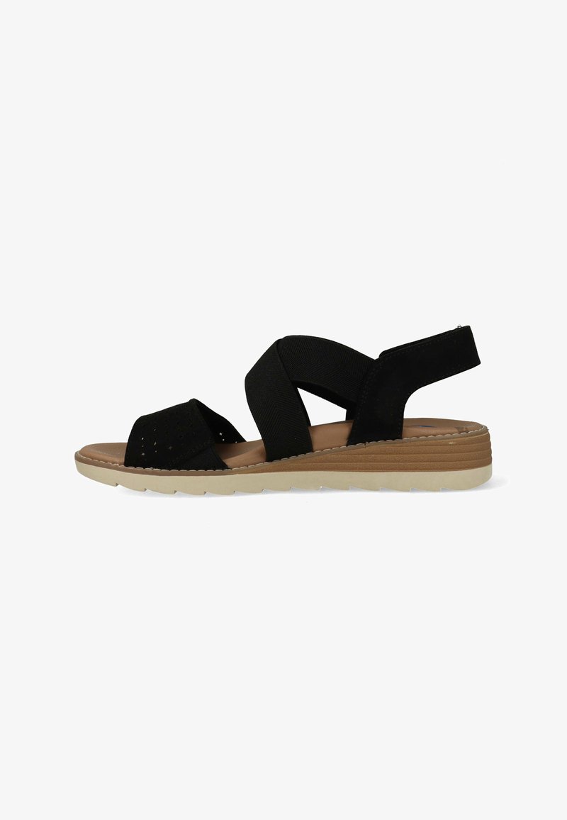 Sandale noire avec brides élastiques croisées, semelle intérieure beige rembourrée et semelle plate beige avec un petit talon pour un usage décontracté.