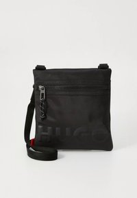 Black nylon crossbody bag with adjustable strap, featuring a front zip pocket, textured logo print, and a slight sheen finish.