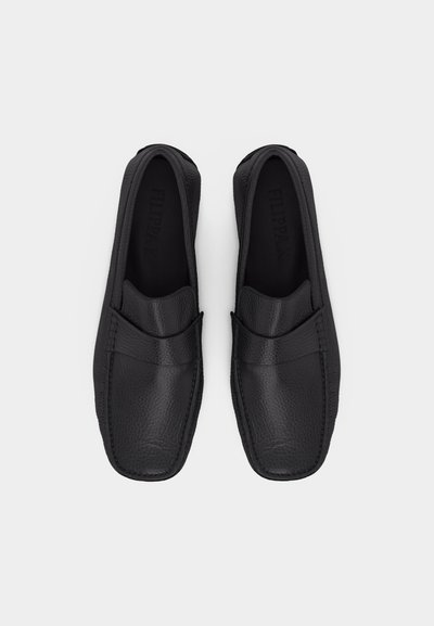 Coppia di mocassini slip-on in pelle nera con punta quadrata e cuciture minime, mostrati dall'alto su uno sfondo grigio chiaro.
